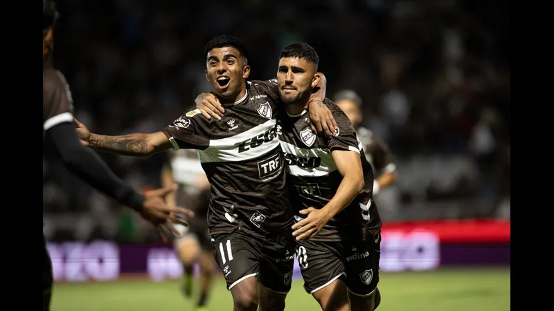 Cầu thủ của Platense vượt qua cầu thủ của Deportivo Riestra trong trận đấu bóng đá